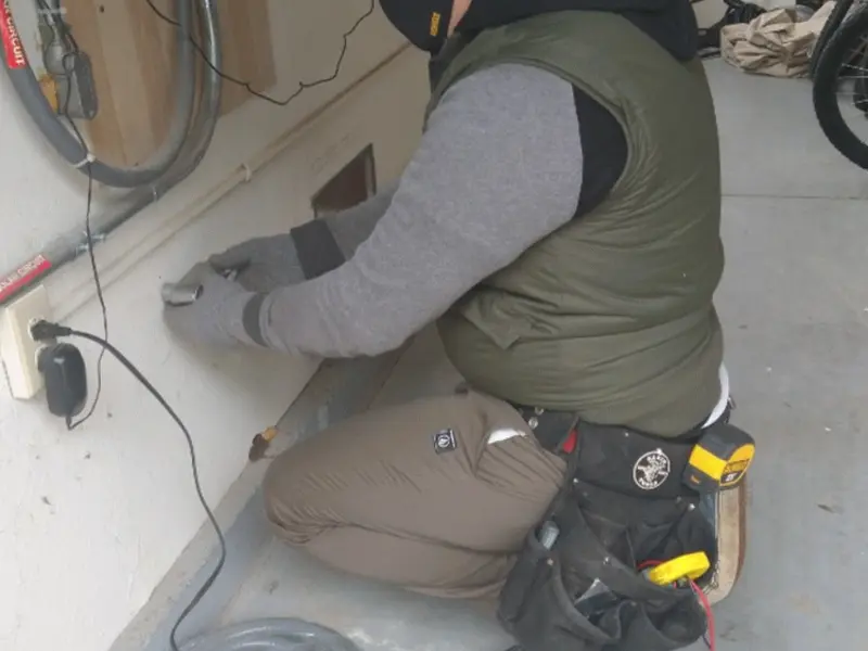 Electrician performing outlet wiring in a Berwyn Heights garage